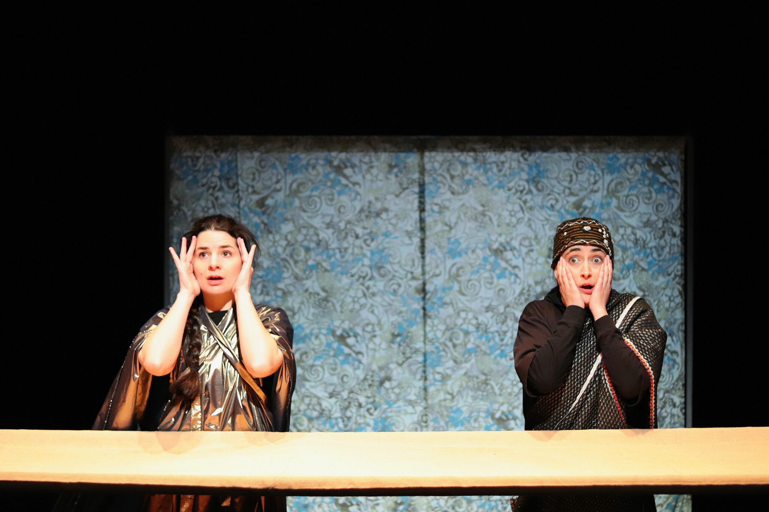 Deux personnages se tiennent le visage et regardent une scène choquante.